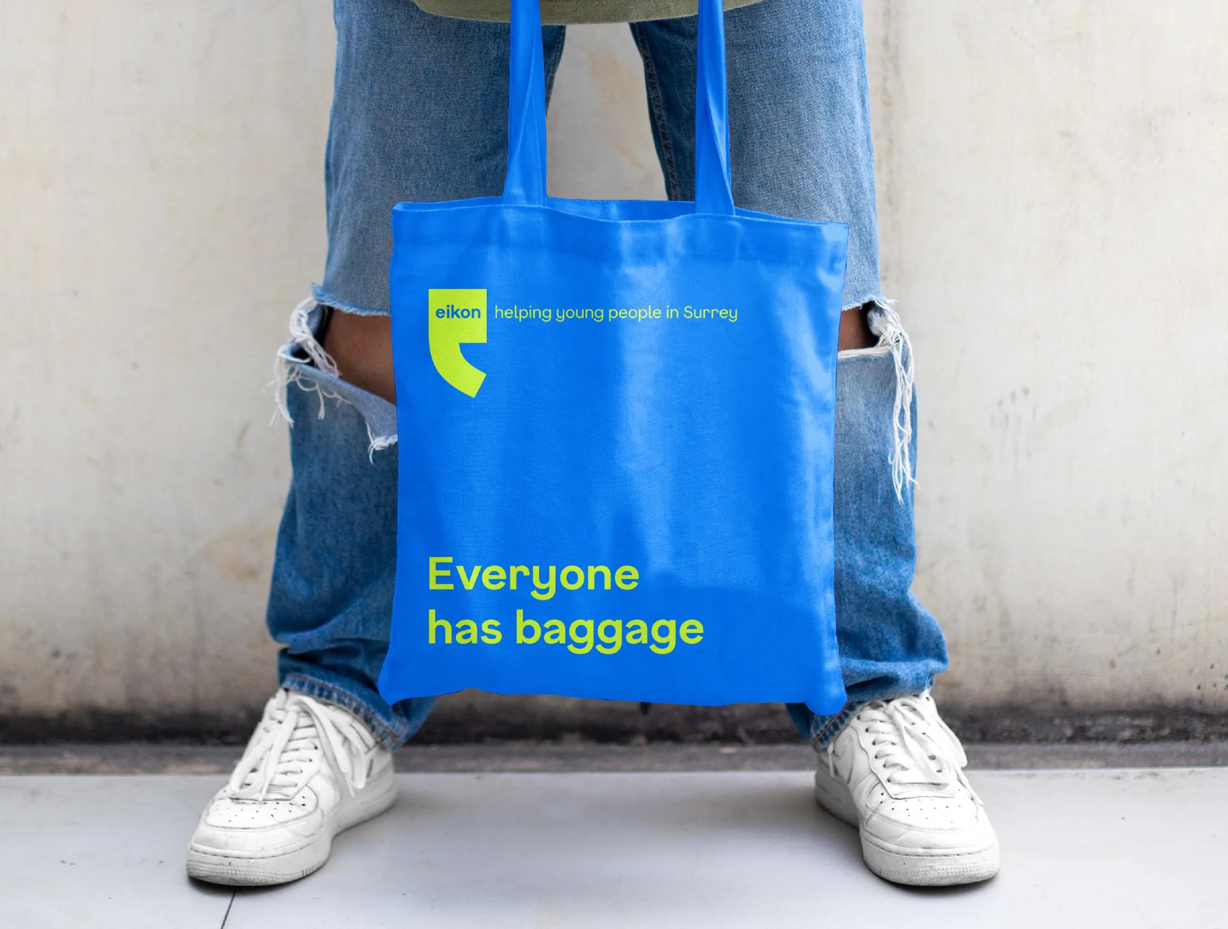 Eikon tote bag with 'everyone has baggage' on it