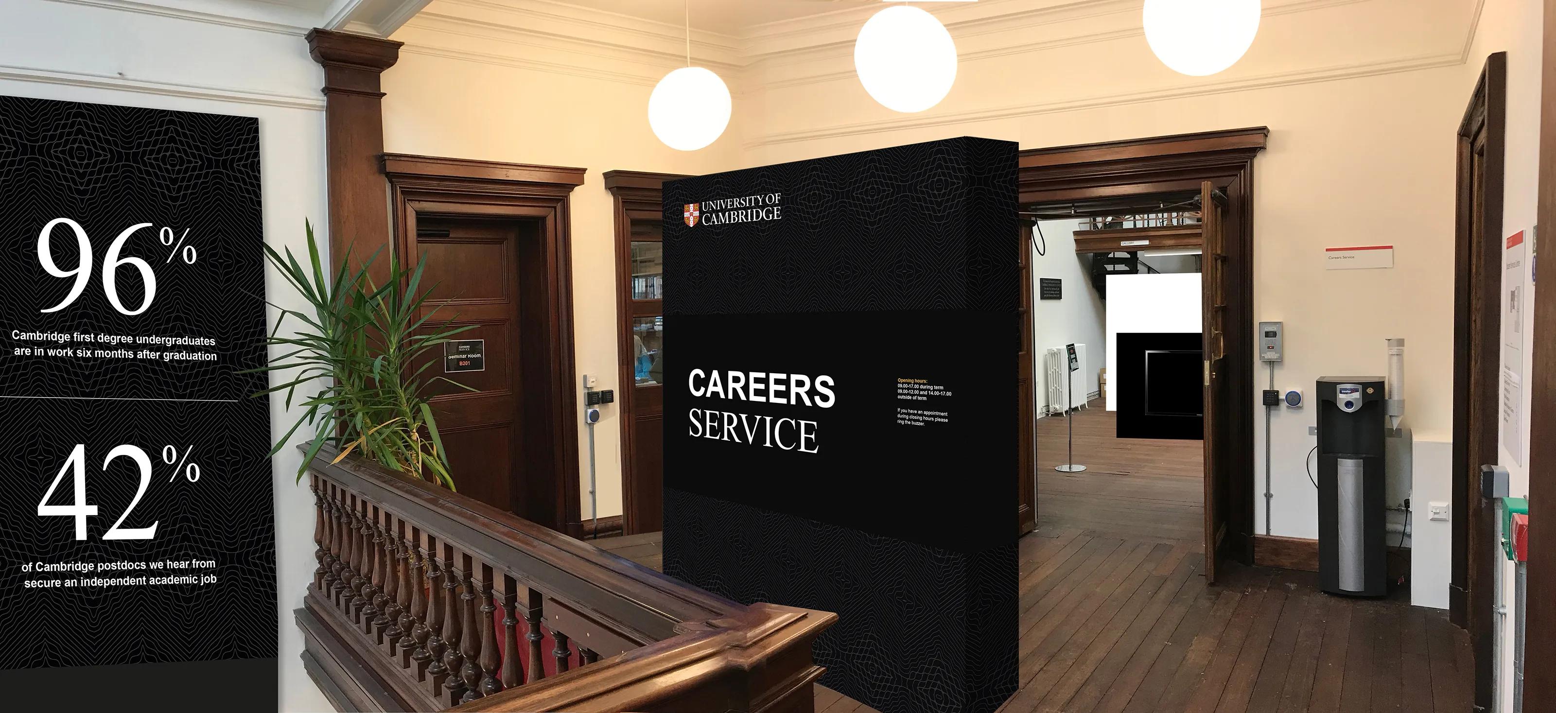 Foyer with a wall of statistics and an exhibition stand for careers 