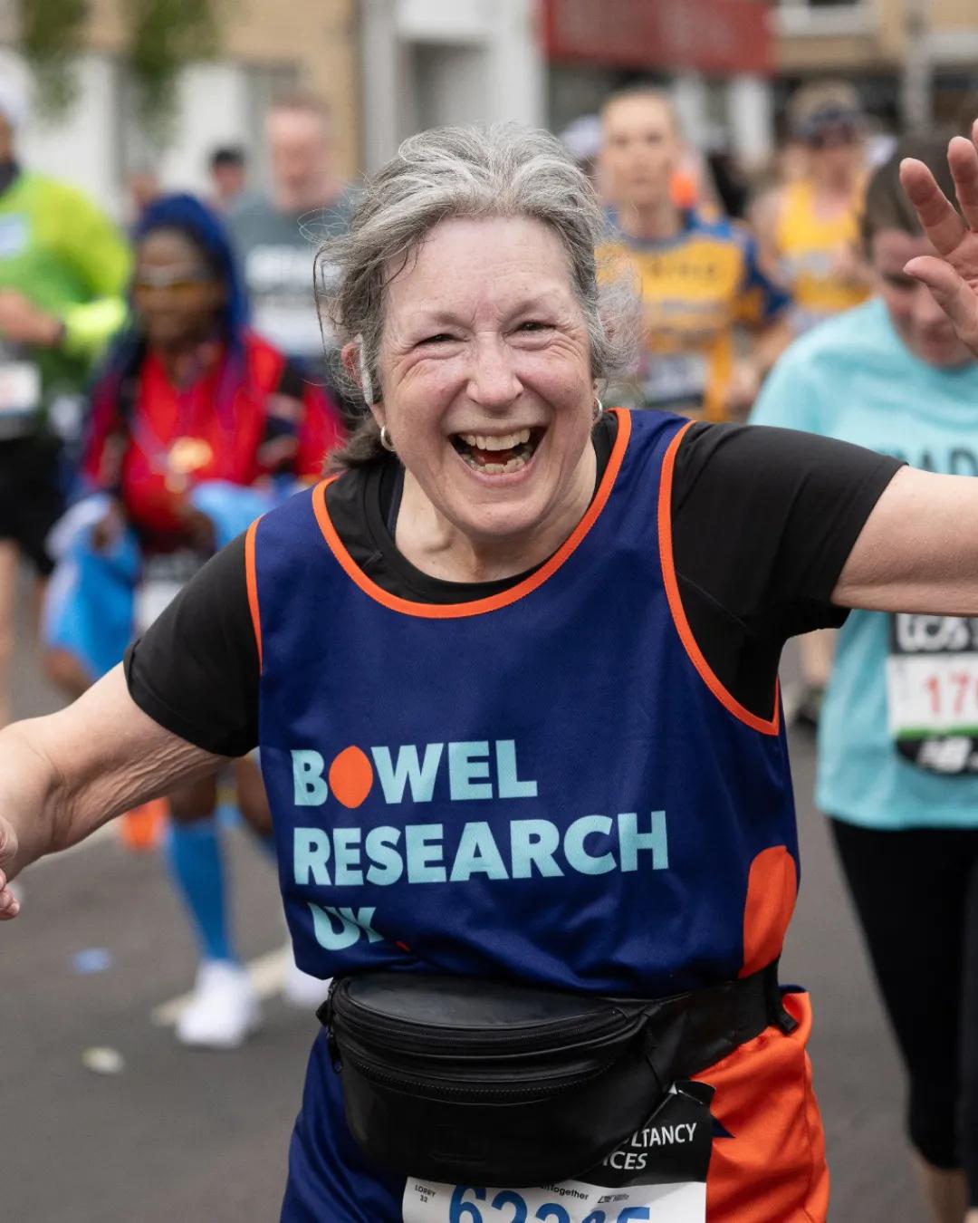 Woman running with a bowel research uk vest