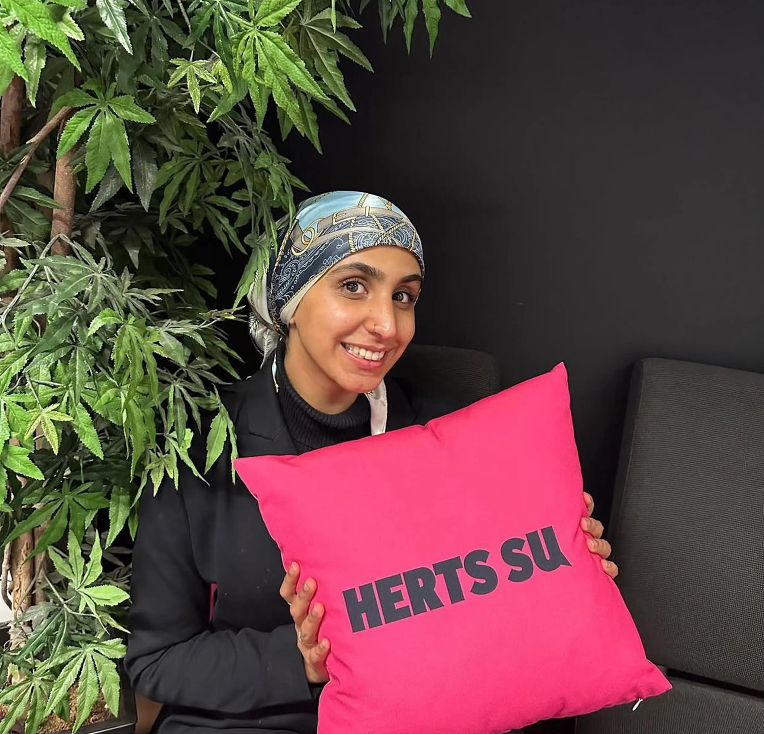 Woman holding the Herts SU pillow