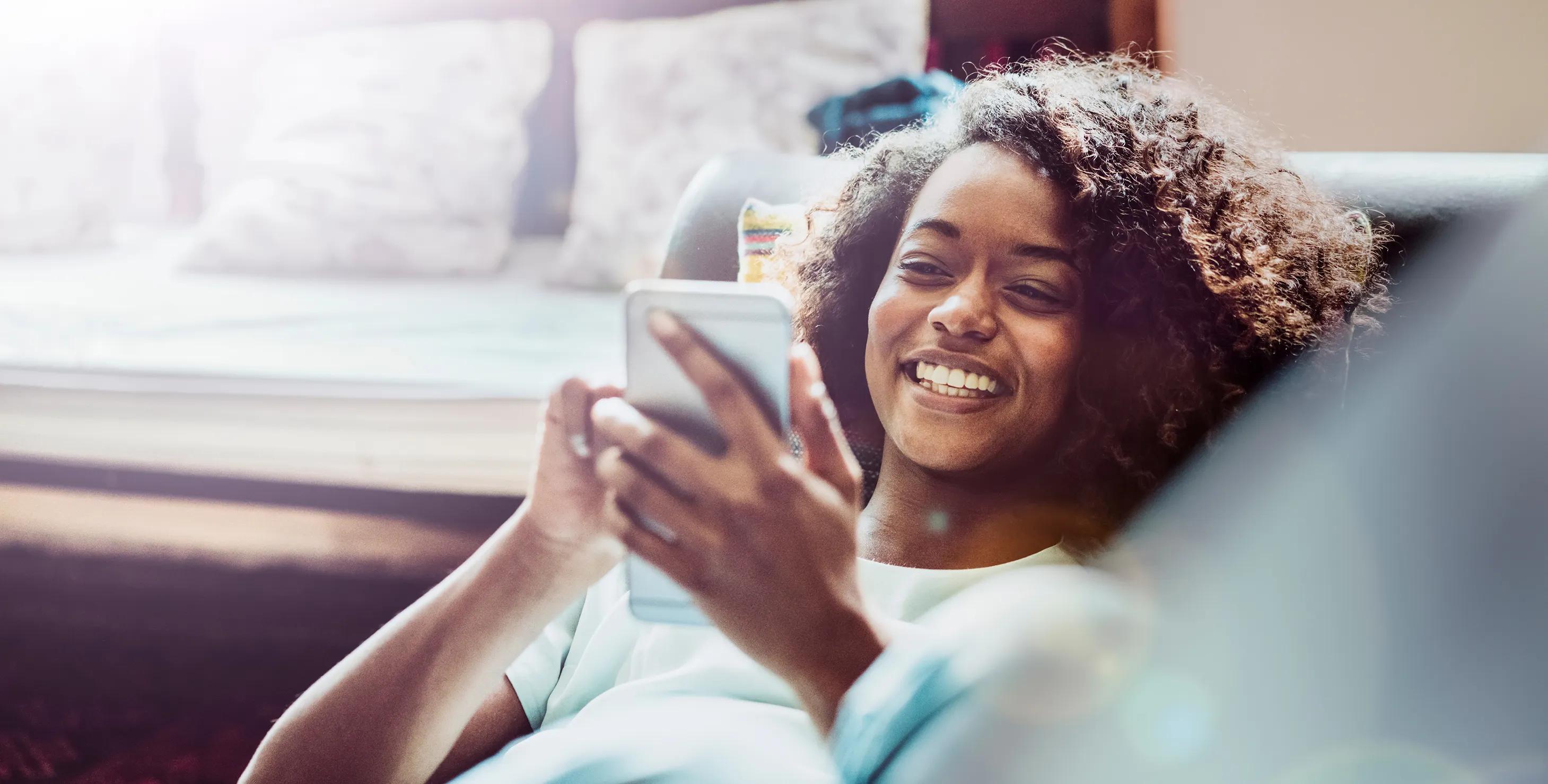 Girl smiling while looking at her phone